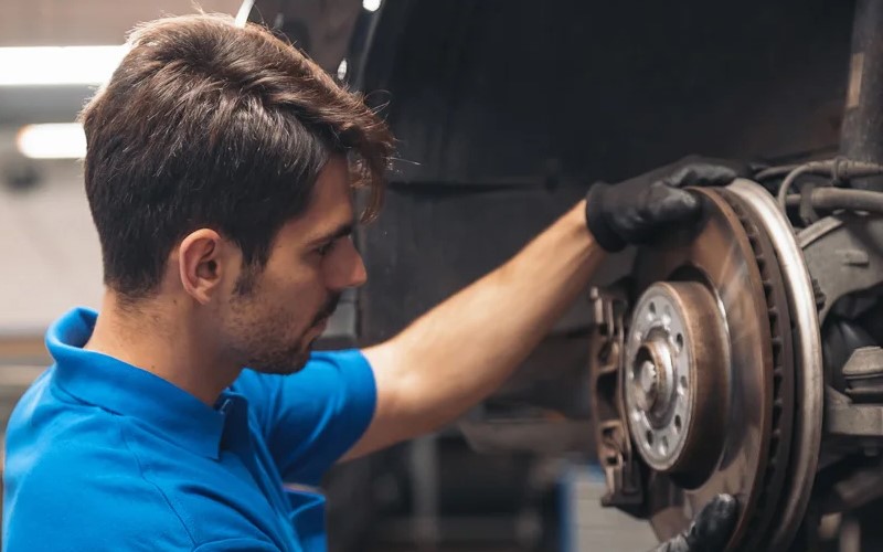 GMC mechanic inspecting a vehicle's wheel.